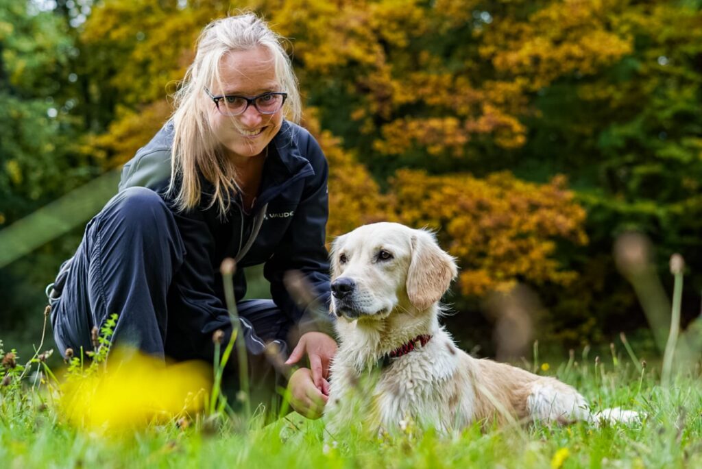 Melanie Thelen mit ihrer Hündin Filla auf einer Wiese